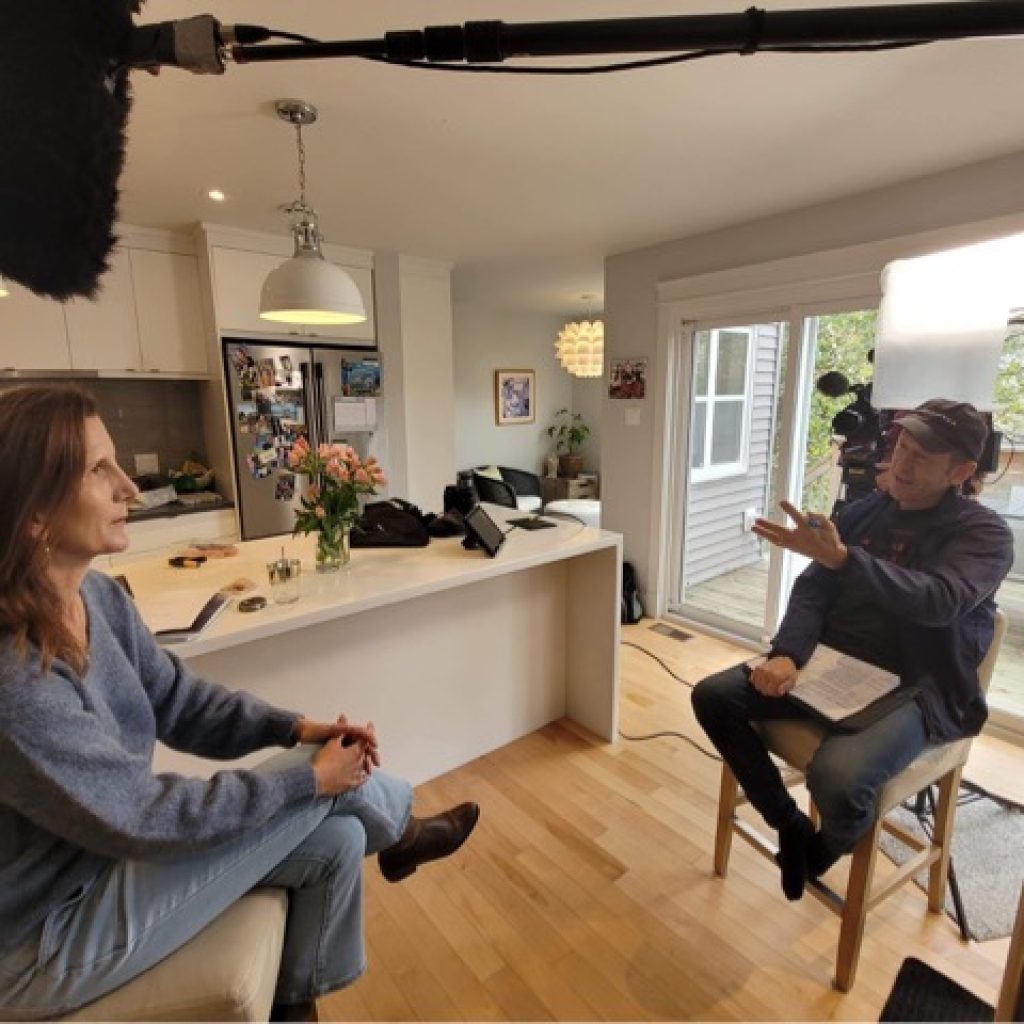 Karen is interviewed in a kitchen with cameras and a microphone